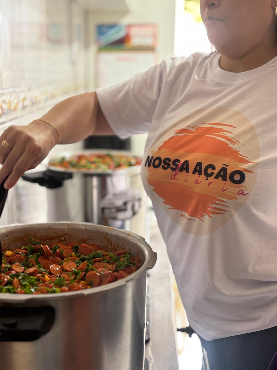 Voluntária mexendo uma panela grande de comida