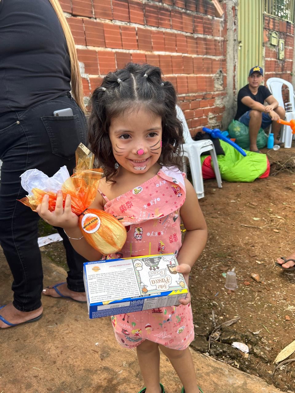 Menina de rosto pintado sorrindo com ovo de Páscoa e mensagem de fé