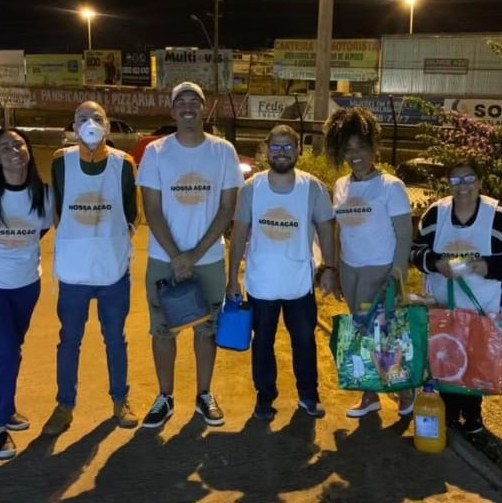 Equipe de voluntários de colete da Nossa Ação, nas ruas à noite
